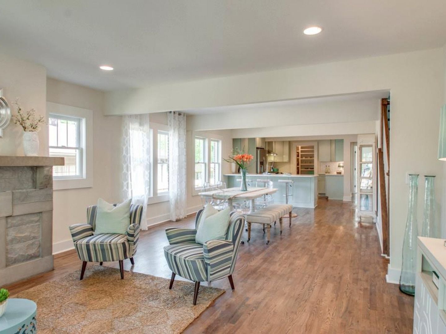 Light-filled living and dining room opening onto a pale blue kitchen