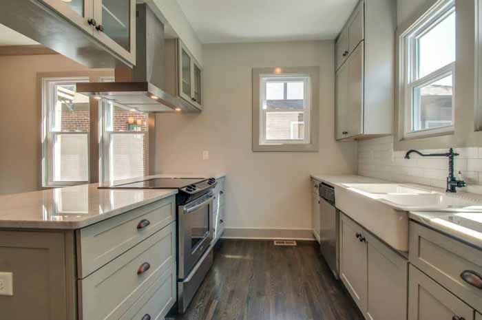 Light galley kitchen with a farmhouse sink and wood floor
